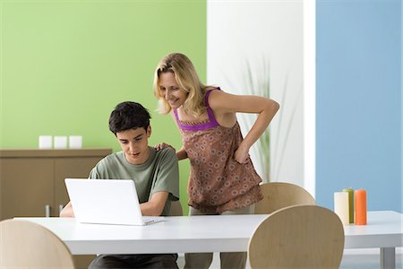 Teenage boy showing mother laptop computer Stock Photo - Premium Royalty-Free, Code: 695-05771304