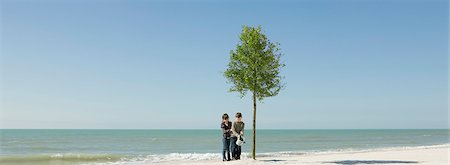 ecology - Children watering tree growing on beach Stock Photo - Premium Royalty-Free, Code: 695-05771517
