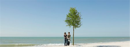 Children watering tree growing on beach Stock Photo - Premium Royalty-Free, Code: 695-05771517