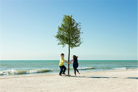 Enfants dansant autour de cet arbuste sur la plage Photographie de stock - Premium Libres de Droits, Code: 695-05771512