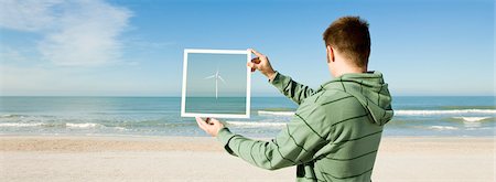 simsearch:632-03500777,k - Offshore wind turbine on horizon viewed from beach Foto de stock - Royalty Free Premium, Número: 695-05771522