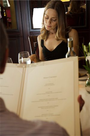 fine dining people not eye contact - Couple reading menus in restaurant Stock Photo - Premium Royalty-Free, Code: 695-05771557