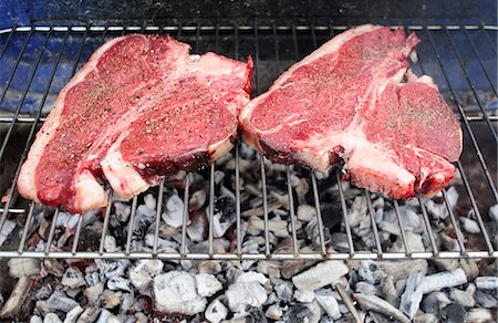 steak grilled from above - Uncooked T-bone steaks on barbecue grill Stock Photo - Premium Royalty-Free, Code: 695-05771649