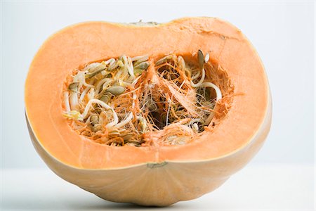 pumpkin seed - Sprouting pumpkin seeds and fibrous strands within cut pumpkin, cross section Foto de stock - Sin royalties Premium, Código: 695-05771775