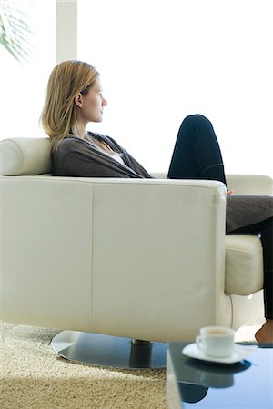 Woman relaxing in armchair, looking out window Foto de stock - Sin royalties Premium, Código: 695-05771838