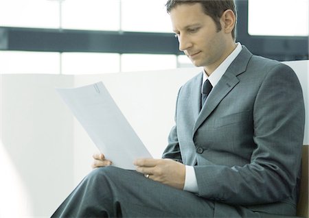 simsearch:633-03194783,k - Businessman sitting and reading document Stock Photo - Premium Royalty-Free, Code: 695-05771943