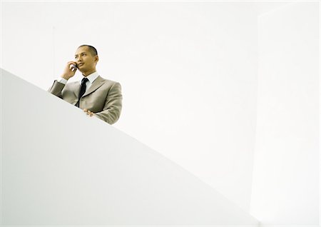 simsearch:695-03381633,k - Businessman using cell phone, low angle view Stock Photo - Premium Royalty-Free, Code: 695-05771961