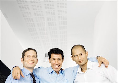 simsearch:695-05763908,k - Businessman standing with arms around two colleagues shoulders Fotografie stock - Premium Royalty-Free, Codice: 695-05771976
