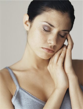 simsearch:695-05777385,k - Young woman with eyes closed resting head on hands, portrait Stock Photo - Premium Royalty-Free, Code: 695-05772294