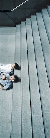 Two young men lying with heads on steps Stock Photo - Premium Royalty-Free, Code: 695-05772299