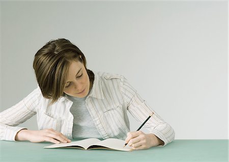 Young woman writing in notebook Stock Photo - Premium Royalty-Free, Code: 695-05772313