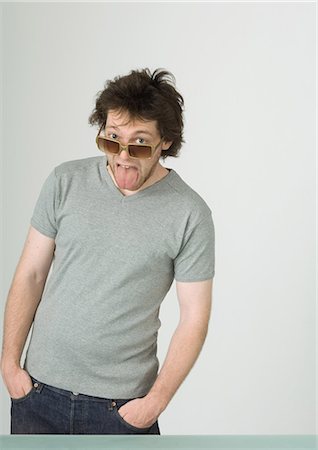 simsearch:695-03374312,k - Young man wearing sunglasses, sticking out tongue Foto de stock - Sin royalties Premium, Código: 695-05772332