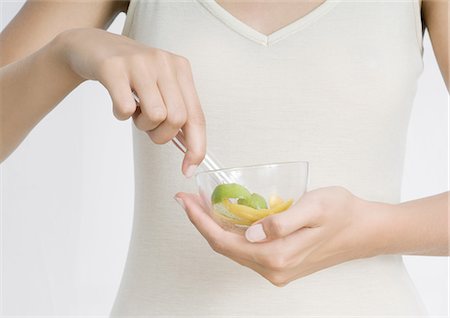 Young woman holding bowl with lemon peel and herbs Stock Photo - Premium Royalty-Free, Code: 695-05772350