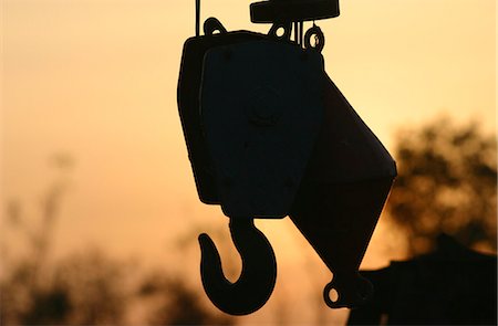 simsearch:700-00077486,k - Crane hook silhouetted at sunset Foto de stock - Royalty Free Premium, Número: 695-05772392