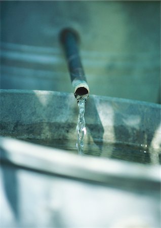 Water trickling from metal pipe into bucket, extreme close-up Stock Photo - Premium Royalty-Free, Code: 695-05772570