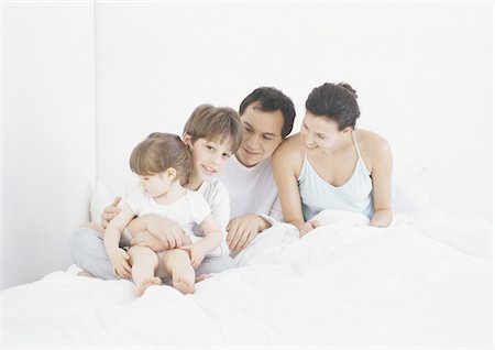 simsearch:695-03385318,k - Family sitting in bed together Foto de stock - Royalty Free Premium, Número: 695-05772656