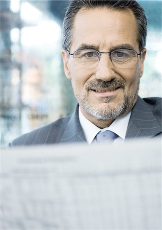 paper moustache - Businessman reading newspaper Stock Photo - Premium Royalty-Free, Code: 695-05772671