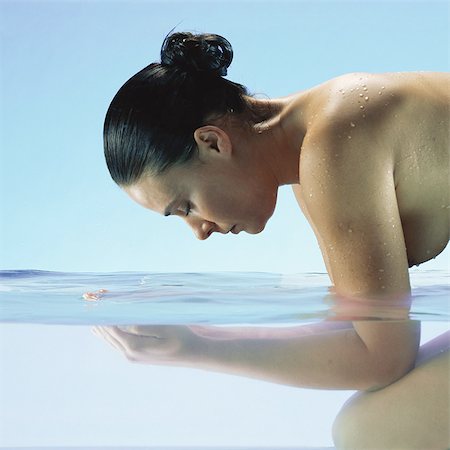 Woman in water, facing water, side view Stock Photo - Premium Royalty-Free, Code: 695-05772717