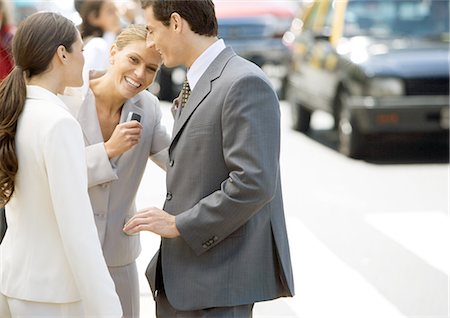 Business associates standing on side of street, woman laughing Stock Photo - Premium Royalty-Free, Code: 695-05772737