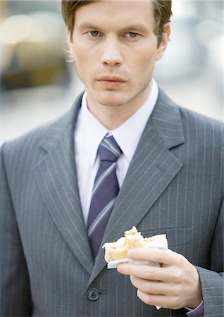 Young businessman holding half-eaten sandwich Foto de stock - Sin royalties Premium, Código: 695-05772752