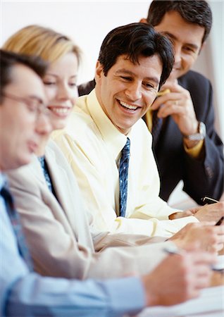 simsearch:696-03398874,k - Business people sitting side by side at a table, smiling Stock Photo - Premium Royalty-Free, Code: 695-05772951