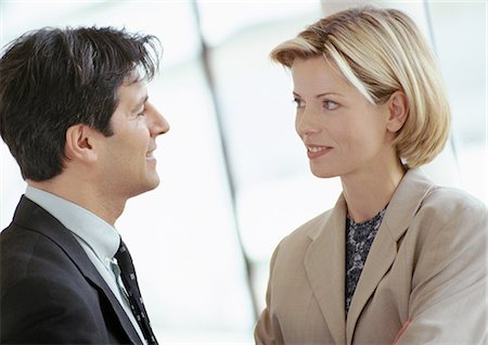 Businessman and businesswoman standing face to face, close-up Foto de stock - Sin royalties Premium, Código: 695-05772969