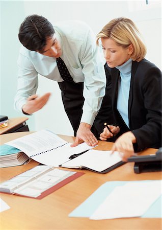 Businessman and businesswoman looking at documents on desk Stock Photo - Premium Royalty-Free, Code: 695-05772985