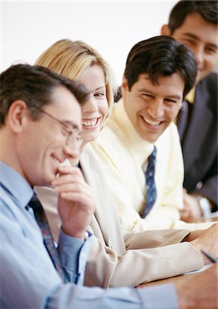 Four businesspeople sitting side by side, smiling Fotografie stock - Premium Royalty-Free, Codice: 695-05772982