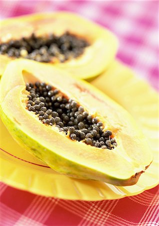 Two papaya halves on yellow plate, close-up Fotografie stock - Premium Royalty-Free, Codice: 695-05773074