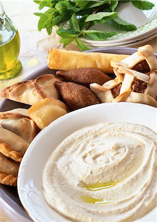 Bowl of hummus with middle eastern turnovers, close-up Fotografie stock - Premium Royalty-Free, Codice: 695-05773099