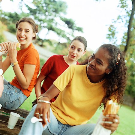 Young women eating sandwiches together outside Stock Photo - Premium Royalty-Free, Code: 695-05773170