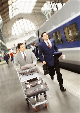 running suitcase - Businessmen running on train platform, blurred. Stock Photo - Premium Royalty-Free, Code: 695-05773265
