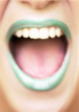 Close up of woman's mouth open and smiling with green lipstick, blurred Stock Photo - Premium Royalty-Free, Code: 695-05773312