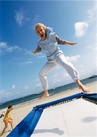 Mature woman jumping on trampoline at the beach Foto de stock - Sin royalties Premium, Código: 695-05773389