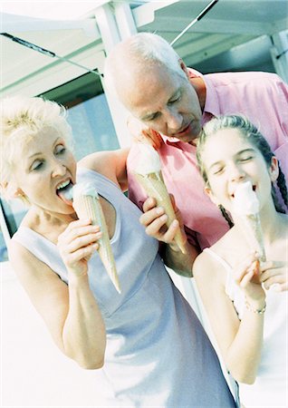 photo of family eating icecream - Mature couple and young girl eating ice cream cones outside Stock Photo - Premium Royalty-Free, Code: 695-05773409