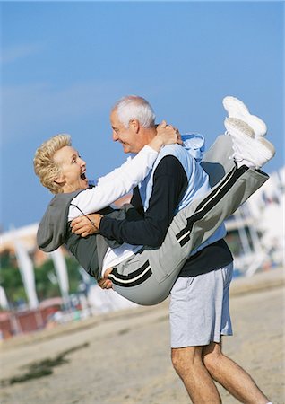 Mature man holding mature woman on beach Foto de stock - Sin royalties Premium, Código: 695-05773414