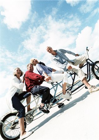 friends laughing tilted - Mature couples on tandem bike at beach, portrait Stock Photo - Premium Royalty-Free, Code: 695-05773418