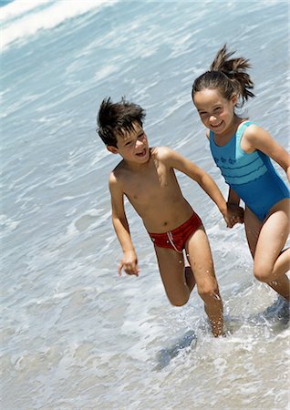 sister and brother running on beach in summer - Two children holding hands in the water at the beach. Stock Photo - Premium Royalty-Free, Code: 695-05773957
