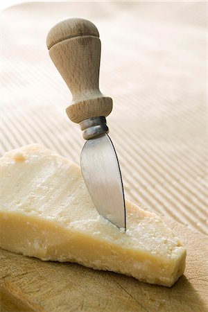 parmigiano-reggiano - Cheese knife stuck in chunk of Parmaesan cheese Foto de stock - Sin royalties Premium, Código: 695-05780026