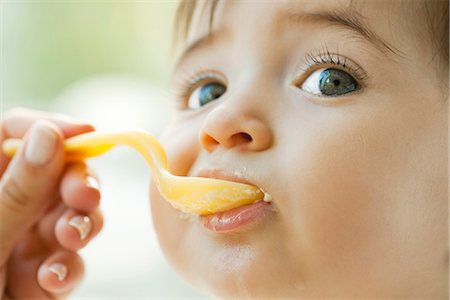 Infant being fed with a spoon Foto de stock - Sin royalties Premium, Código: 695-05780171