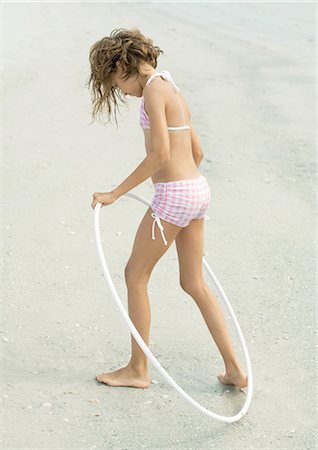 Girl playing with plastic hoop on beach Stock Photo - Premium Royalty-Free, Code: 695-03374034