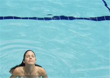 Woman standing in pool, head back and eyes closed, front view Stock Photo - Premium Royalty-Free, Code: 695-03374111