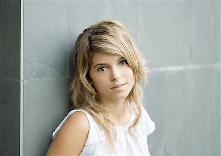 reluctant teen girl - Young woman leaning against wall, portrait Stock Photo - Premium Royalty-Free, Code: 695-03374297