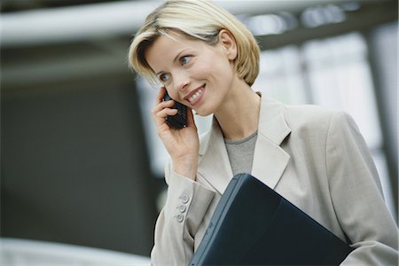 simsearch:695-03380514,k - Businesswoman using phone, holding laptop Stock Photo - Premium Royalty-Free, Code: 695-03374478