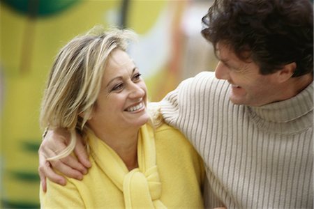 simsearch:695-03374588,k - Middle aged couple smiling at each other, man's arm around woman's shoulders Stock Photo - Premium Royalty-Free, Code: 695-03374526