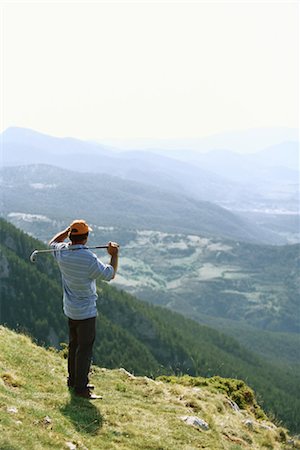 shielding eyes back view - Golfer standing, overlooking mountainous landscape Stock Photo - Premium Royalty-Free, Code: 695-03374632