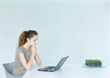 Woman using laptop, tray of wheatgrass on table Foto de stock - Sin royalties Premium, Código: 695-03374648