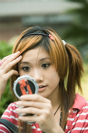 simsearch:632-01271797,k - Young woman looking at self in pocket mirror Stock Photo - Premium Royalty-Free, Code: 695-03374679