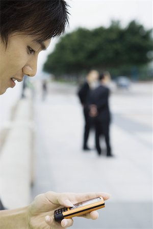 simsearch:632-01271089,k - Young man looking at cell phone Stock Photo - Premium Royalty-Free, Code: 695-03374819