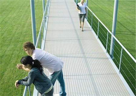 simsearch:695-05764382,k - Teenage couple leaning against rail of walkway while businesswoman approaches Stock Photo - Premium Royalty-Free, Code: 695-03374852